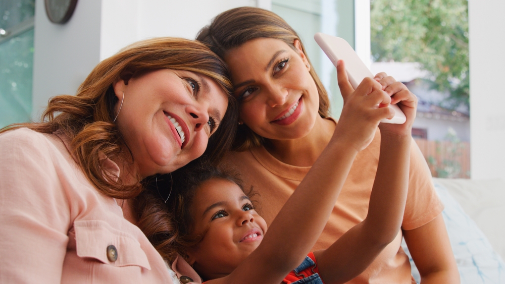 A grandmother, mother, and young daughter smile beautifully for a selfie. Keep smiles healthy for every generation with regular Hygiene Treatment & Exams at Wilder Dentistry
